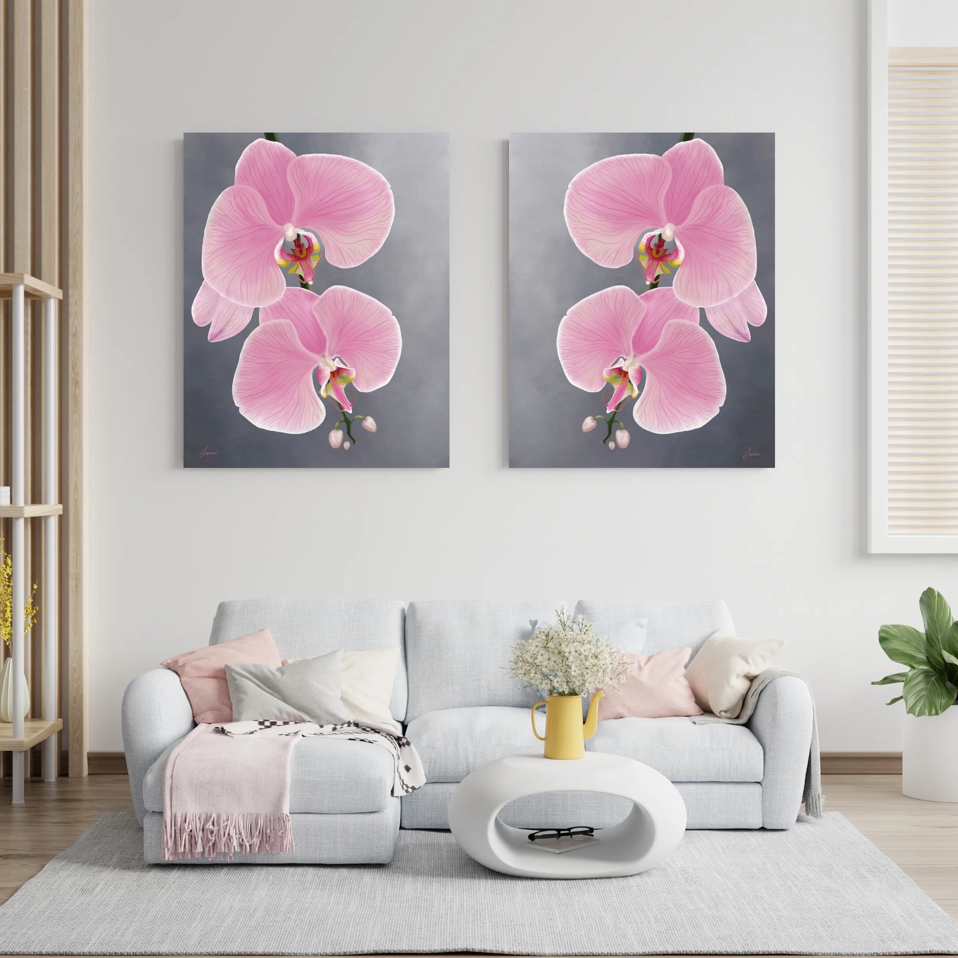 A modern living room features a light gray sofa with pastel pillows, a pink throw, and a white oval coffee table topped with a yellow vase of flowers. Above the sofa, gallery-wrapped canvas paintings of pink orchid add elegance to the gray wall.