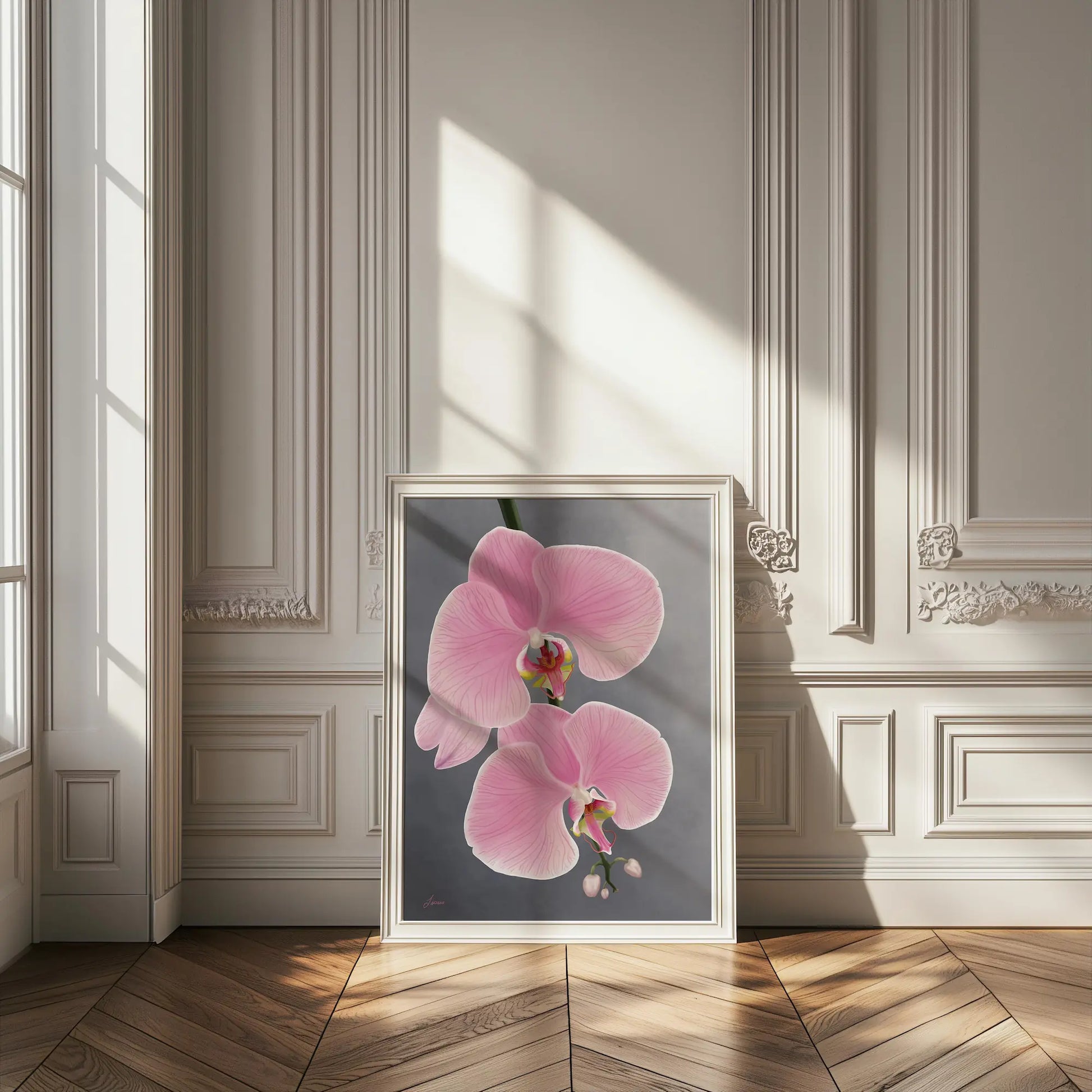 A framed painting of pink orchids in a floating wood frame leans against an ornate white wall in a sunlit room. Sunlight casts soft shadows on the herringbone floor, highlighting the elegant, classic interior and decorative molding.