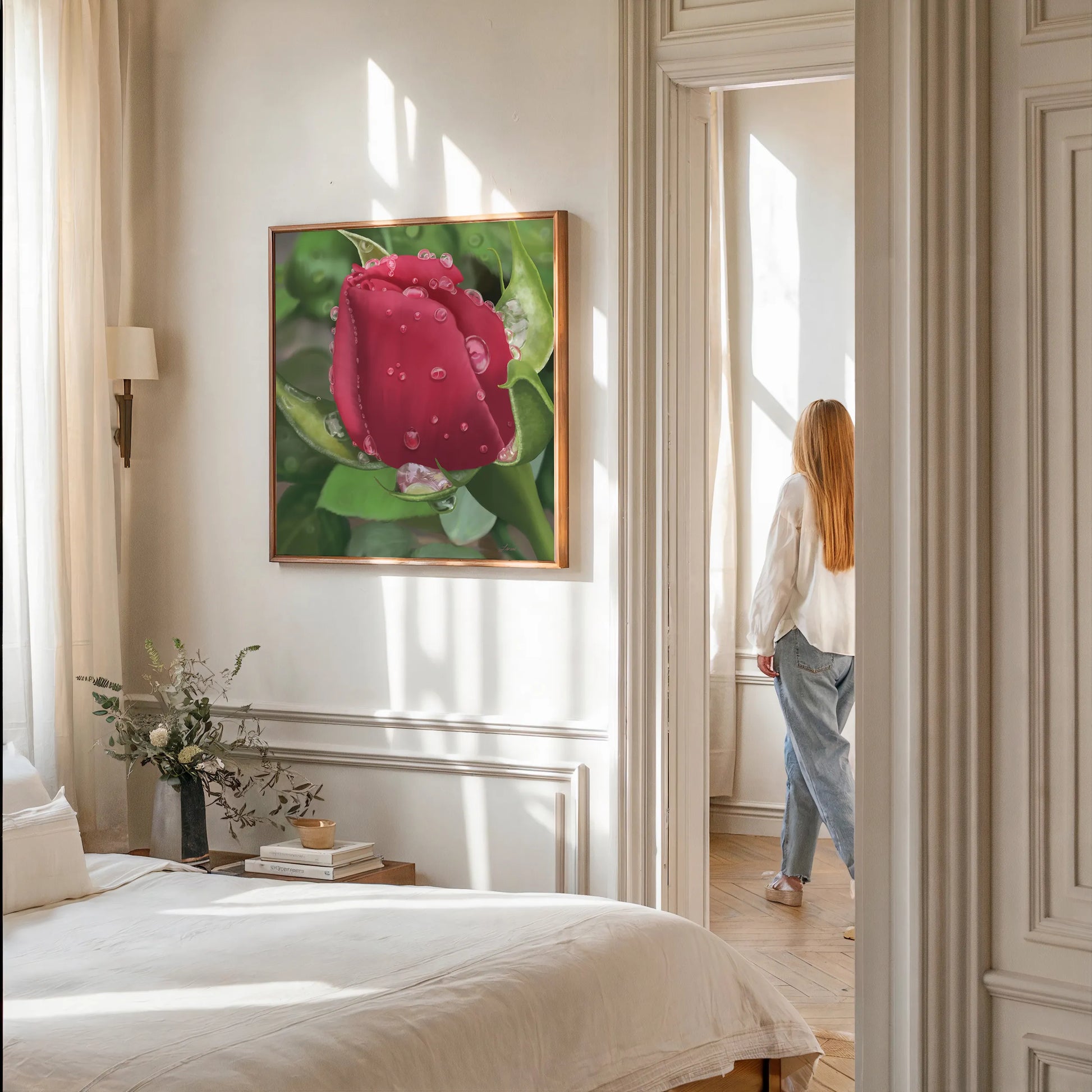 A woman with long hair, dressed in a light blouse and jeans, stands by a sunlit window in a cozy bedroom. The room features white linens, natural elegance with greenery, and a canvas art print of a red tulip with water droplets on the wall.