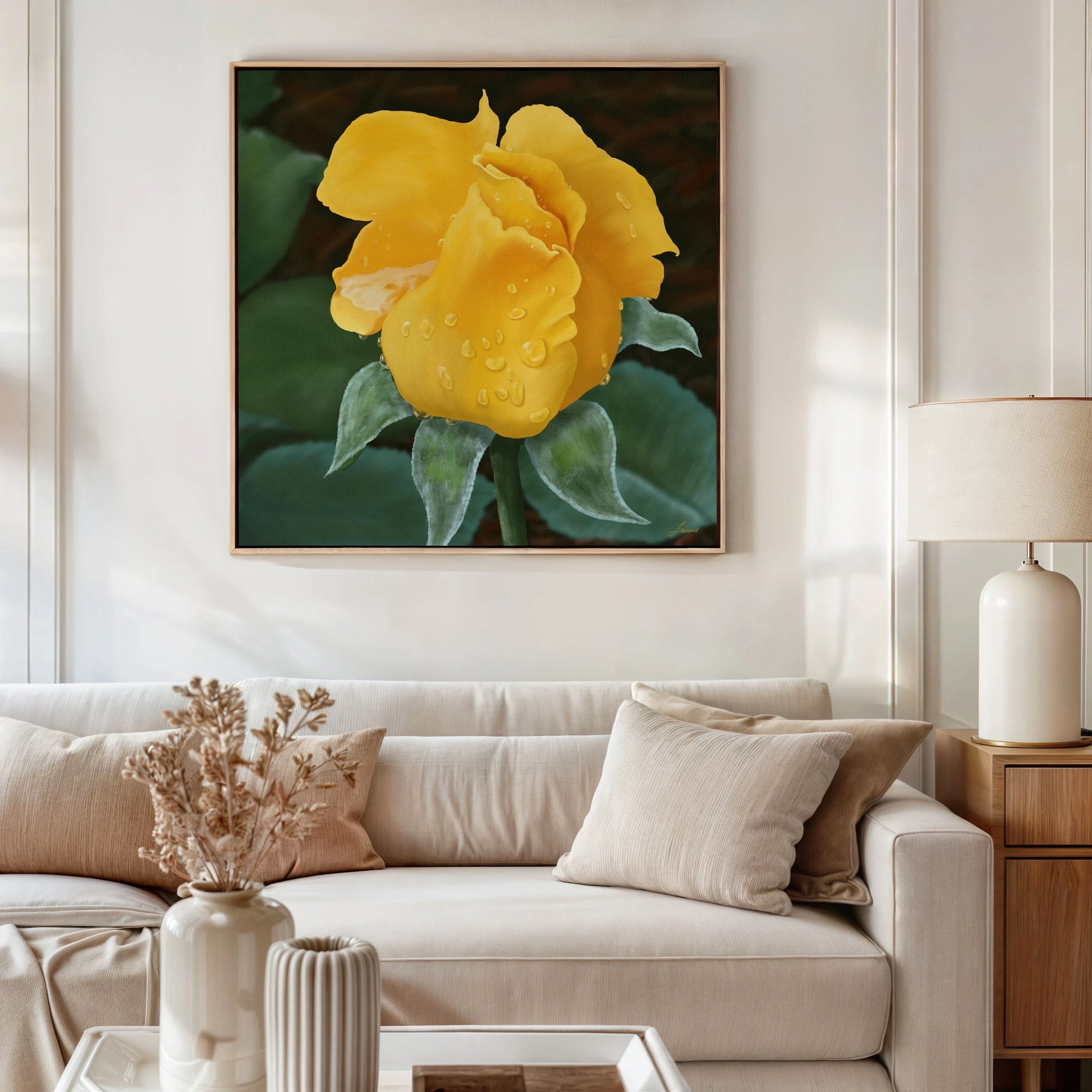 A modern living room with a cream sofa, beige cushions, a wooden side table with a lamp, and a vase of dried flowers. Above the sofa hangs a yellow rose canvas in floating frame options, printed with vibrant eco-solvent ink.