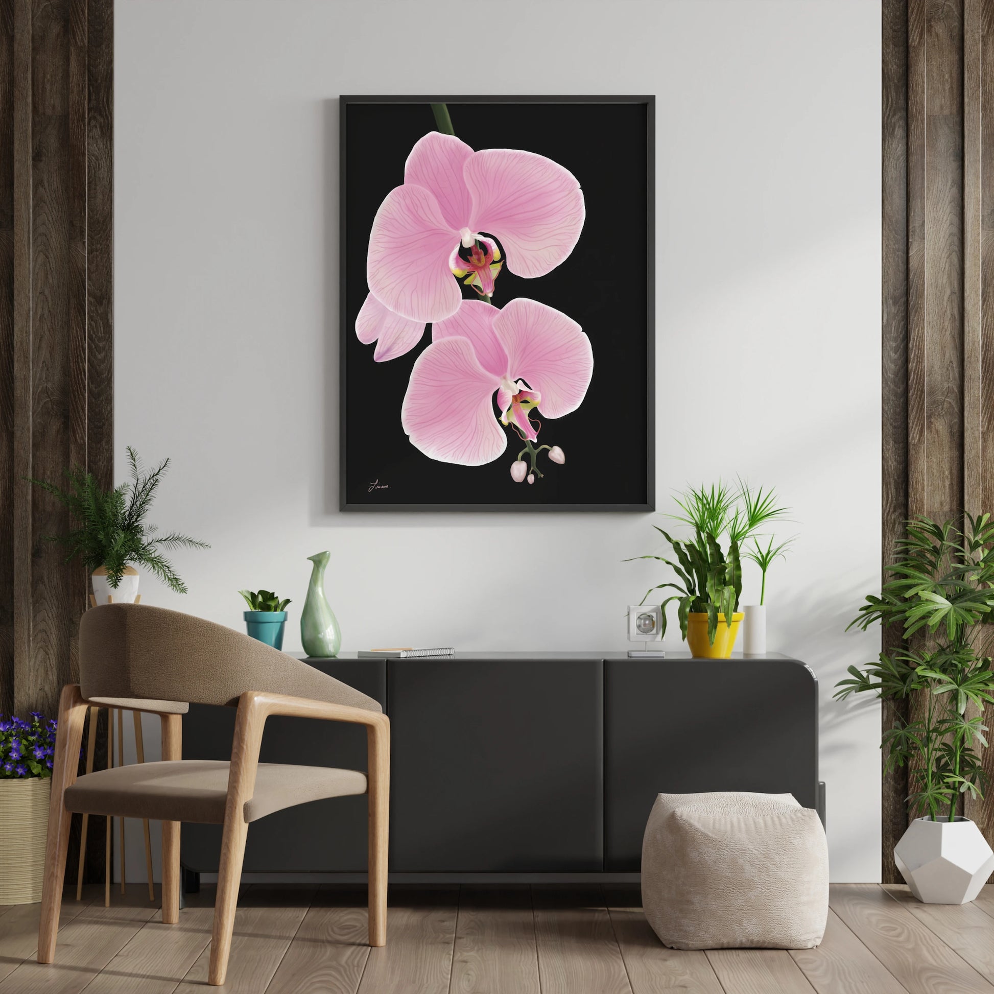 A modern living room with wood-accented walls, a premium canvas titled Midnight Bloom featuring two pink orchid flowers, a light armchair, white ottoman, lush green plants, and decorative vases atop a sleek black cabinet.