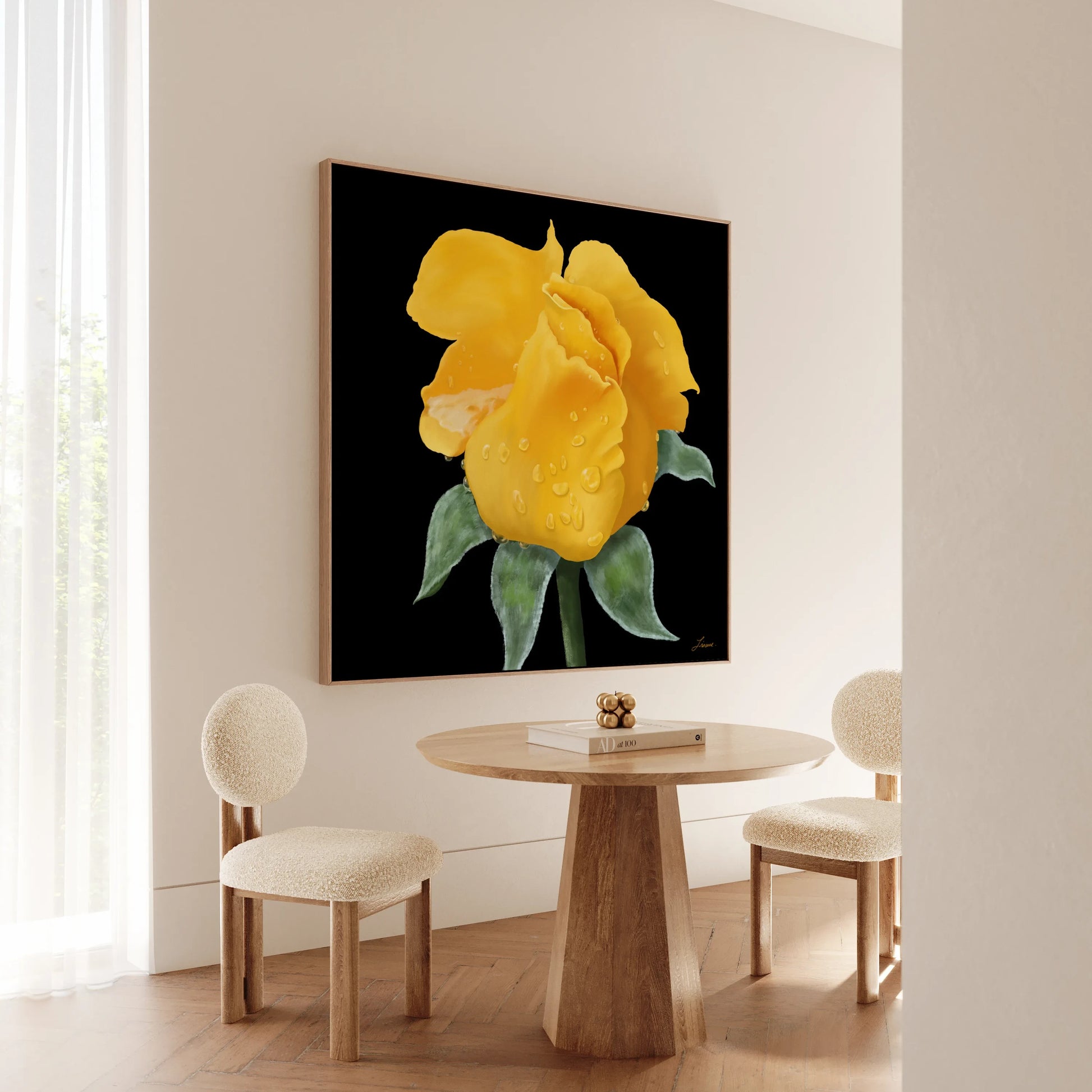 A modern, minimalist room features a round wooden table, two textured cream chairs, and a premium gallery-wrapped canvas of a yellow rose with water droplets. Soft natural light filters through sheer curtains, illuminating the striking artwork.