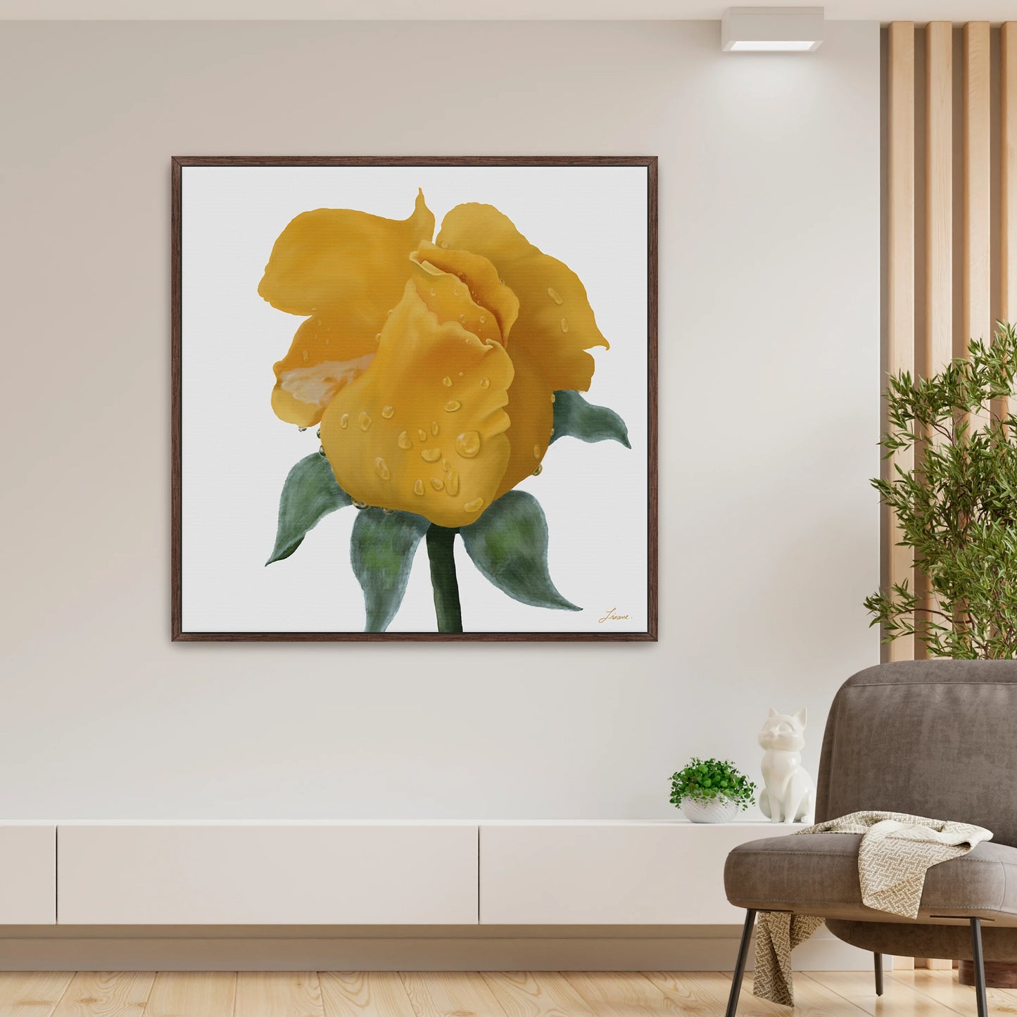 A modern living room showcases a vibrant yellow rose canvas art print with water droplets on a white background. Beneath, a white shelf holds green plants and a small cat figurine. To the right, a gray armchair with a draped blanket complements the contemporary interiors.