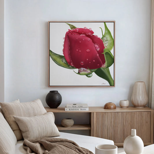 A modern, neutral-toned living room with a beige sofa, cream pillows, wooden furniture, and minimalist decor. Above the sofa hangs Refreshing Love, a red rosebud painting on a gallery-wrapped canvas with a floating wood frame.