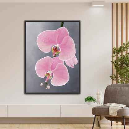 Modern living room featuring a delicate pink orchid canvas art by Lisane Art, with graceful blooms gently reaching toward the left against a soft grey background- enclosed in a sleek black floating frame. 