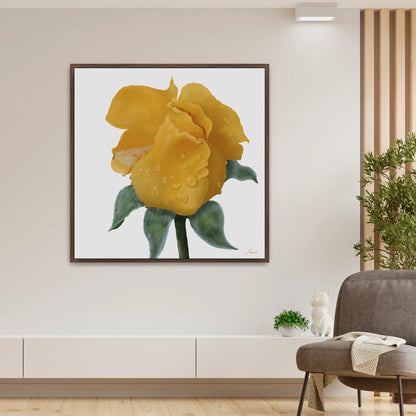A modern living room showcases a vibrant yellow rose canvas art print with water droplets on a white background. Beneath, a white shelf holds green plants and a small cat figurine. To the right, a gray armchair with a draped blanket complements the contemporary interiors.